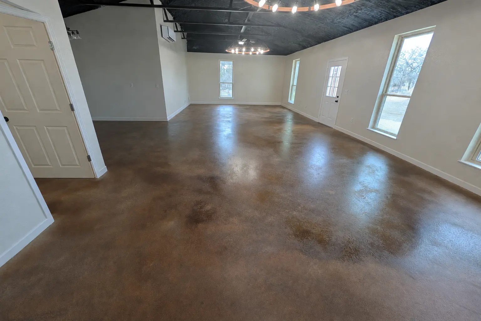 Interior event and meeting hall at Journey's RV Park in Temple, Texas, with polished concrete floors, natural light, and chandelier lighting